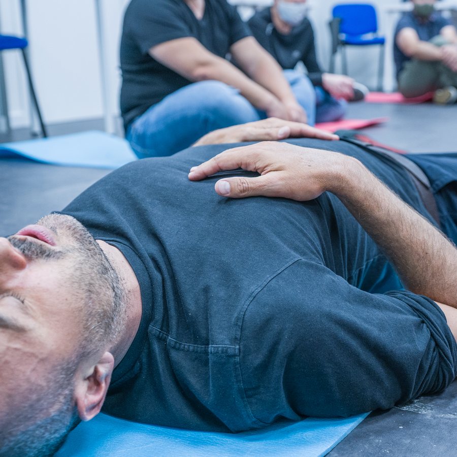 Alumno tumbado practicando apnea en seco con la mano en el abdomen